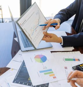 Business professionals discussing financial graphs and charts in an office setting.